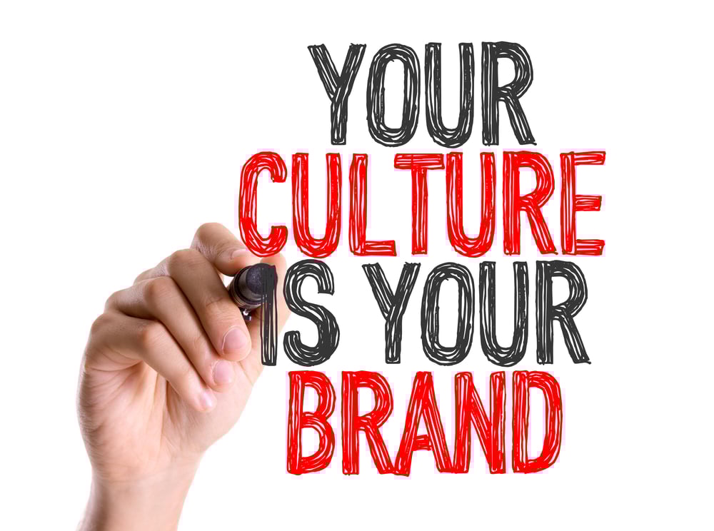 Hand with marker writing Your Culture Is Your Brand-1