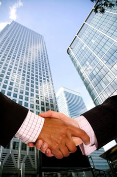 diverse business men shaking hands in a corporate environment - vertical